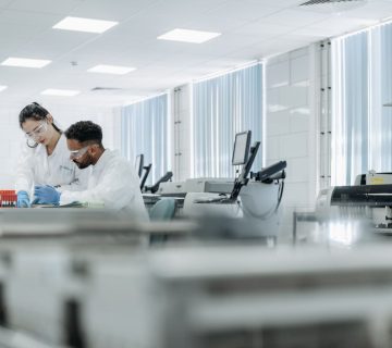 Eş Araştırma laboratuvarında koruyucu ekipmanlı iki bilim insanı