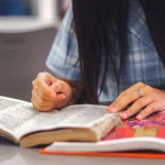 Masada kitap okuyan kadın eş araştırma sürecinde profesyonel bir çalışma yapıyor