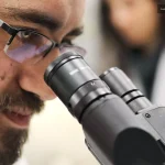 Mikroskopla örnek inceleyen bilim insanı laboratuvar ortamında Eş Araştırma