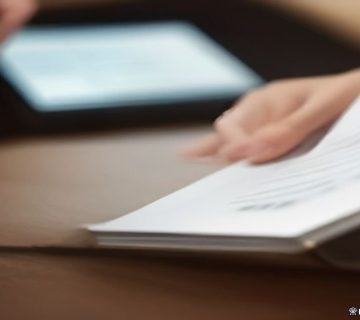 Tablet ekranından otel kaydı belgelerini kontrol eden kişi