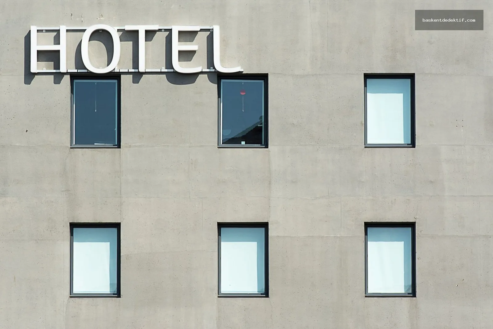 Otel kayıtları çıkartmak için masa başında belgeleri inceleyen misafir