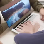 Hotel otel reklamları arkasından silinen dijital ekranlardan uzaklaşan kişinin elini gösteren laptop