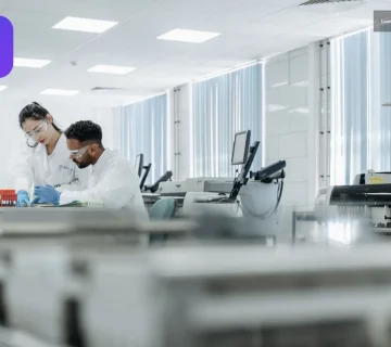 Laboratuvarda koruyucu ekipmanlarla çalışan iki bilim insanı eş araştırma sürecinde