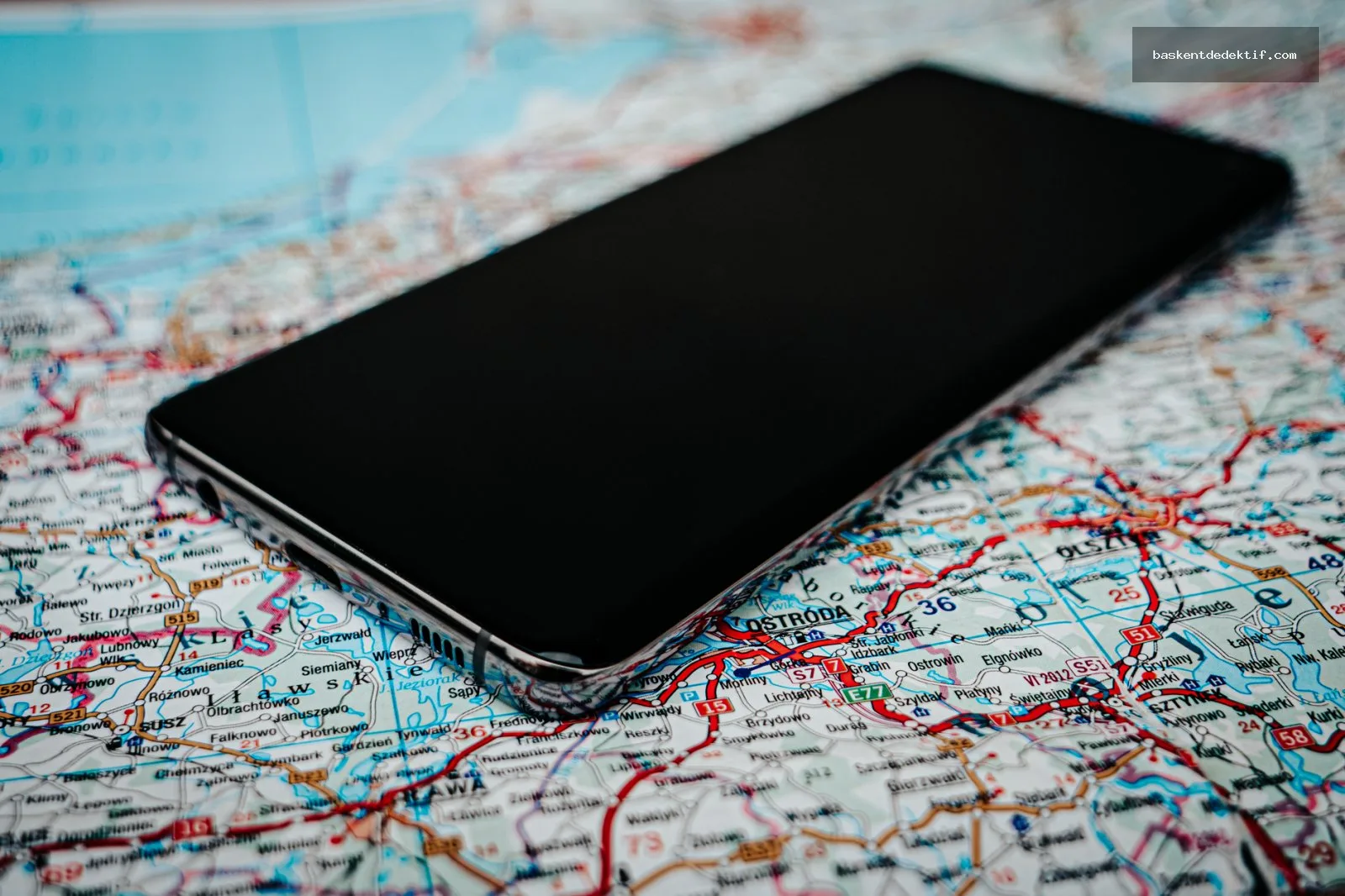 Eş takibi için harita ve akıllı telefon kullanan bir kişi