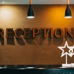 Şık bir resepsiyon masası üzerinde duran otel kayıtları defteri