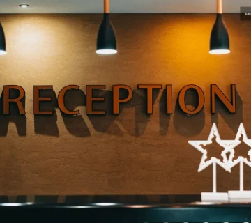 Şık bir resepsiyon masası üzerinde duran otel kayıtları defteri